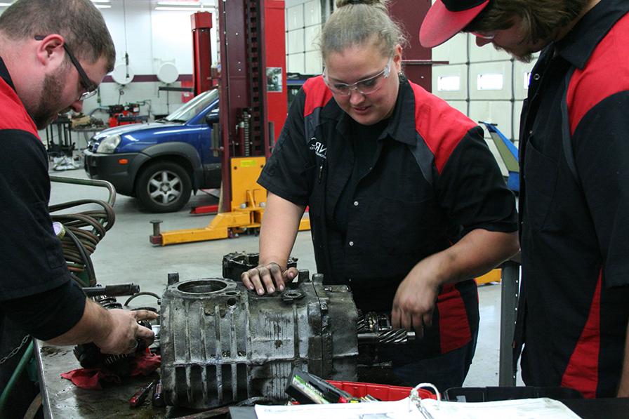 Students hand on to fix car parts